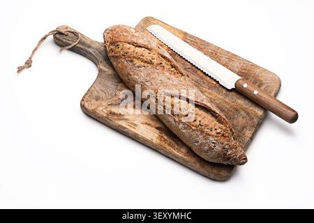 Freshly baked rustic bread baguette with seeds on wooden cutting board isolated on white background Stock Photo