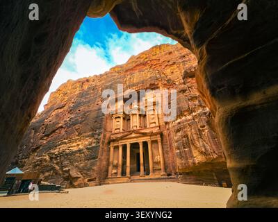 Stunning wide angle view of the iconic Treasury facade at Petra, Jordan, perfectly framed through a natural cave opening in the rose-red sandstone cli Stock Photo