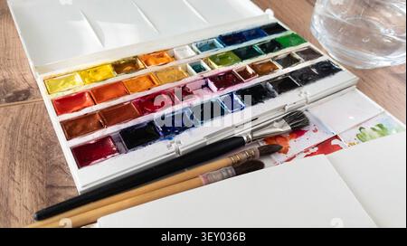 Watercolor paints palette with colorful plastic cuvettes. Bright artist aquarelle blocks set for creative fine art painting hobby. Place for text Stock Photo