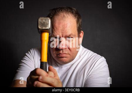 Determined handyman holding a hammer before starting a home repair Stock Photo