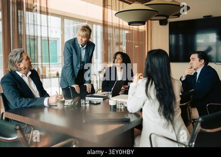 White collar workers sharing ideas with each other during meeting in office board room Stock Photo