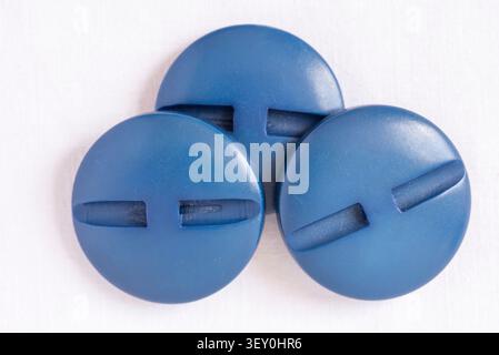 Big Blue Buttons, three vintage buttons on white cotton background Stock Photo
