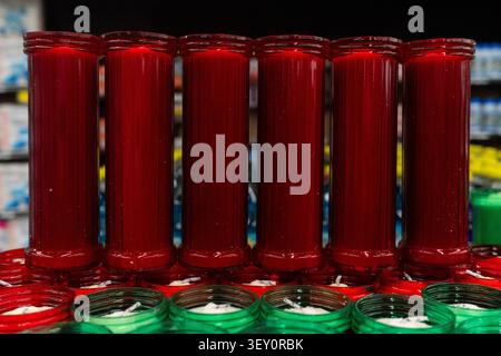 Row of Tall Red Glass Jar Candles with Ribbed Texture and Visible Wicks Stock Photo