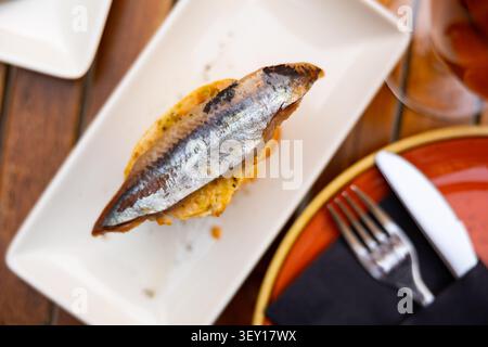 Sandwich with smoked fish sardine are laid out on large platter Stock Photo