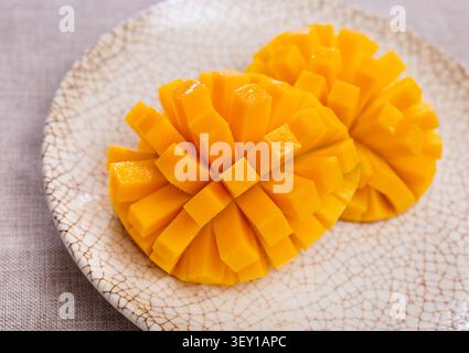 Set with sweet ripe mangoes cut into cubes on plate. Top view Stock Photo