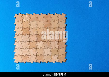 Wooden jigsaw puzzle on blue background finding solutions Stock Photo