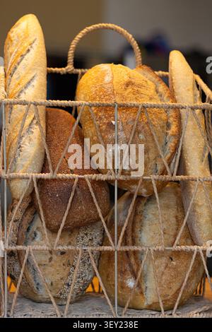Assorted Artisan Bread Loaves in a Wire Basket Stock Photo
