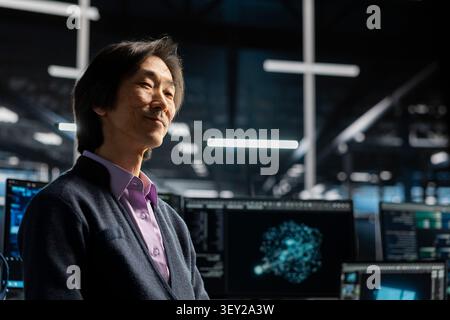 Asian man uses an AI language model assistant in a server hub to handle infrastructure maintenance. Stock Photo