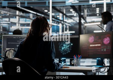Data center engineer reviews cyber threat alerts in a data center while working to protect infrastructure from security breaches. Stock Photo