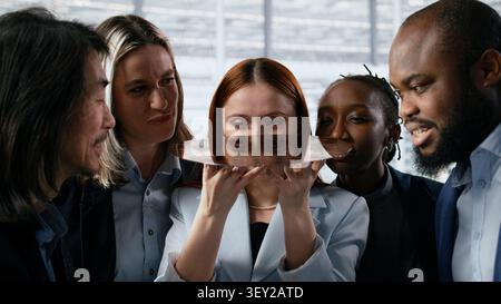 Diverse team of technicians examine semiconductor substrate in microchip research office. Multiethnic coworkers in RD workspace analyzing silicon wafer technology, camera A close up Stock Photo