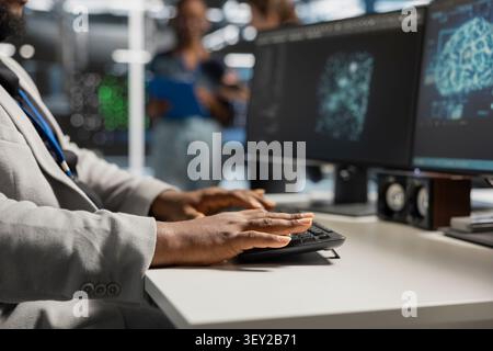 System operator uses a desktop computer in a data center to manage AI systems and optimize server infrastructure. Stock Photo