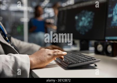 Data center engineer uses a desktop computer in a data center to support failure detection and reliable server workflows. Stock Photo
