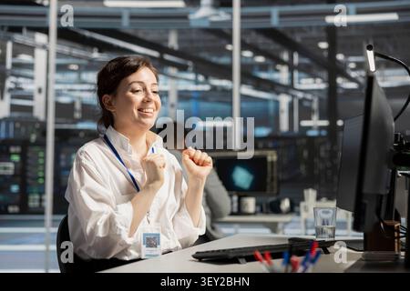 Cheerful IT expert celebrates improved system results in a data center after improved performance and completed server operations. Stock Photo
