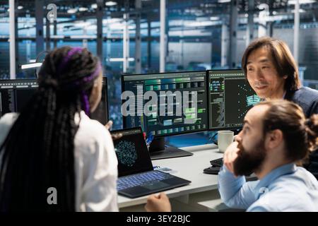 Engineering team works with computer in a data center to support data processing, analytics, and storage infrastructure. Stock Photo