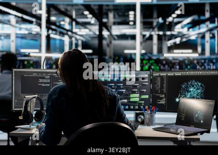 Data center programmer uses a digital device in a data center to support automation monitoring and reliable server workflows. Stock Photo