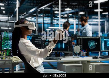Engineer wears a headset in a server hub, using artificial intelligence troubleshooting to assist users. Stock Photo