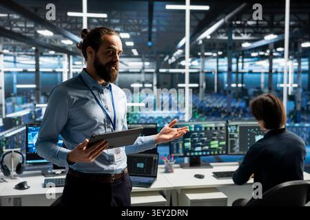 Data center specialist presents AI technology and server infrastructure during a professional high-tech demonstration. Stock Photo