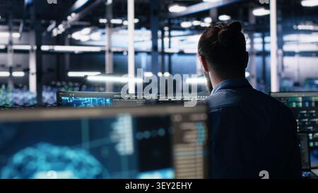Software developer reviews artificial intelligence systems and machine learning processes inside a data center. Stock Photo