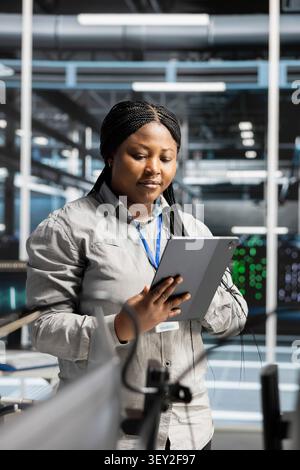 IT specialist works on a computer to monitor AI systems, neural networks and server infrastructure. Stock Photo