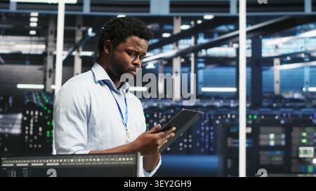Technician uses a computer workstation in a server farm to categorize unstructured data with node tree systems. Stock Photo