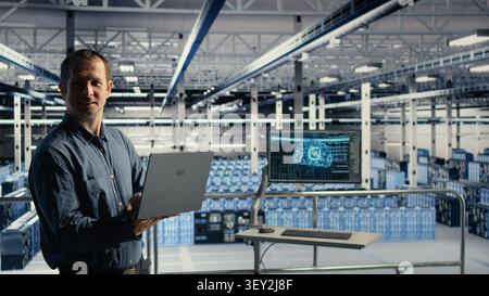 Technical specialist in computing facility checks AI dashboard working with notebook during routine systems check, while tests AI tools on notebook to confirm reliable operational performance. Stock Photo