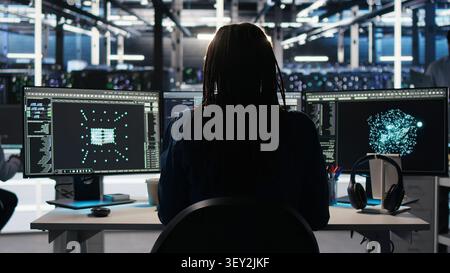 Computing facility computer scientist working with visual programming system to assess datasets with IT staff member working with visual programming to strengthen digital infrastructure performance. Stock Photo