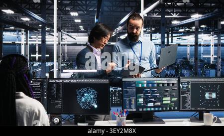 Data infrastructure center team supervisor supervising software developer. Stock Photo