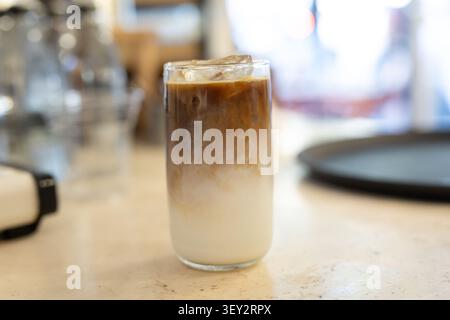 A refreshing close-up of iced mocha coffee served in a tall glass. The drink features rich chocolate, espresso and cold milk with ice cubes. Stock Photo
