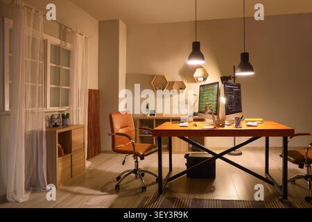 Modern home office workspace with dual monitors and leather chairs Stock Photo