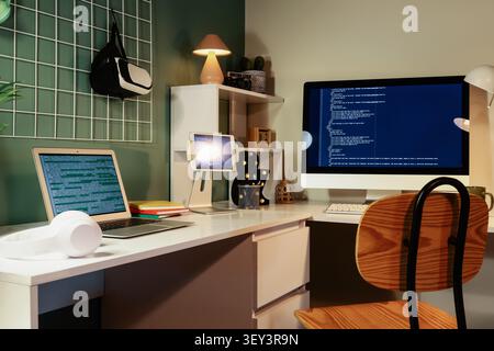 Modern home office workspace with multiple screens and coding Stock Photo