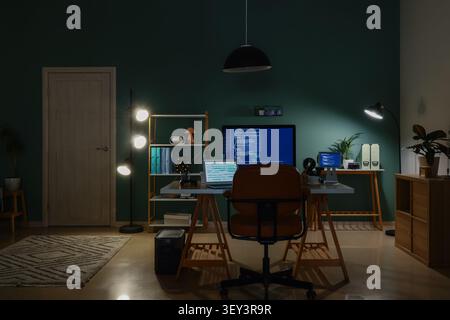 Modern home office with multiple screens displaying code Stock Photo