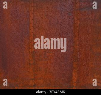 Weathered rust coated steel metal surface with two vertical seams with rows of rivets Stock Photo