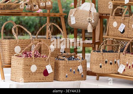 Title:Chiang Mai, Thailand - 27 May 2026 : Woven water hyacinth handbag with pale blue floral embroidery at craft stall Stock Photo