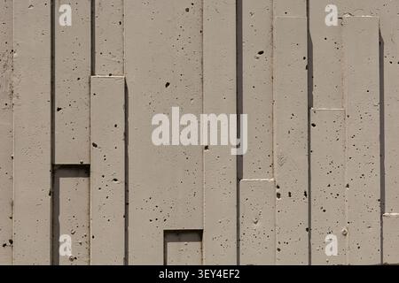 Abstract architectural concrete wall featuring geometric vertical forms, textured surface, and modern minimalist design suitable as a background or co Stock Photo