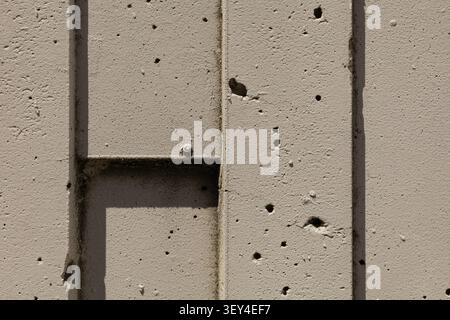 Close-up of an abstract geometric concrete wall featuring textured surfaces, vertical architectural elements, and a minimalist modern design suitable Stock Photo