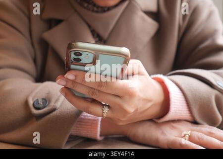 Person uses smartphone while sitting at a table Stock Photo