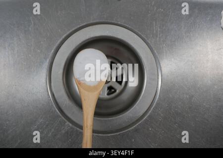 Mixing baking soda in a kitchen sink for cleaning tasks Stock Photo