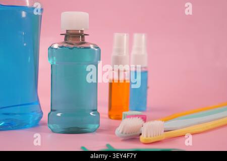Oral care items on a pink background with blue drinks Stock Photo