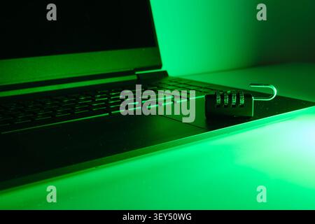 Open padlock resting on a laptop keyboard reflecting data access and security vulnerability Stock Photo