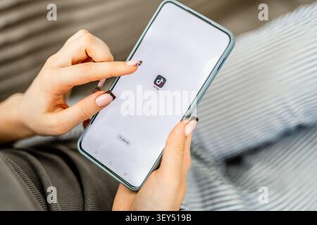 GNIEZNO, POLAND - May 06, 2026: Woman's Hands Holding Phone With Tiktok Icon On Screen Stock Photo
