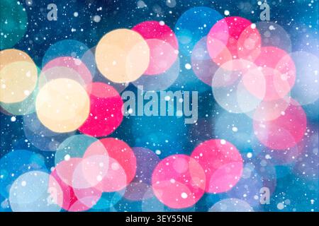 Horizontal festive background filled with colorful red, gold, green, and white bokeh lights on a blue background. Gentle snowfall enhances the magical Stock Photo