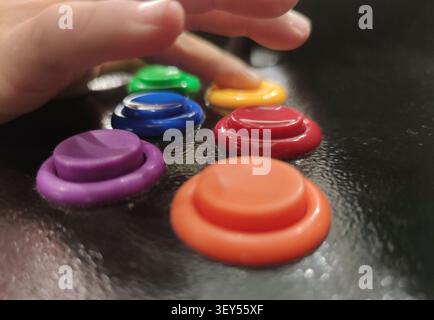 Child boy gamer pressing 6-button arcade controller. Revival of arcade machines Stock Photo