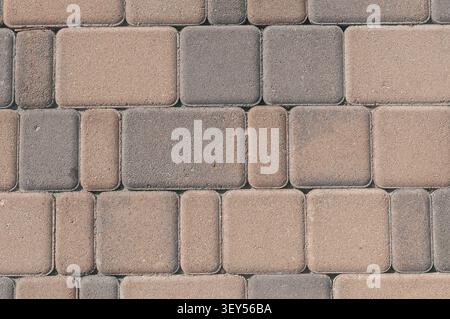 A-close-up-view-of-and-patterned-paving-stones-in-shades-of-gray-and-brown-creating-a-textured-surface-for-outdoor-landscaping-and-walkway-design. Stock Photo