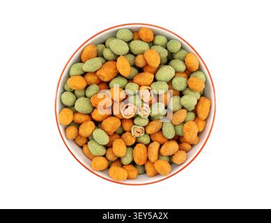 Mix of coated peanuts with wasabi and cayenne chili peppers in a bowl on white background. Spicy snack. Stock Photo