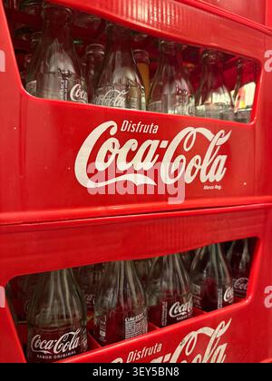 ANDALUSIA, SPAIN - APRIL 20, 2025: Coca-Cola bottles neatly arranged in a red plastic crate, creating an inviting and commercial retail display in a s Stock Photo
