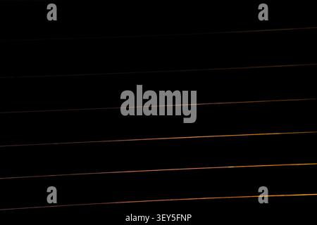 Dramatic fading golden lines on shadowy black background Stock Photo
