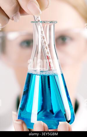 Scientist with a Conical Flask and Thermometor in a Laboratory, Close Up Stock Photo