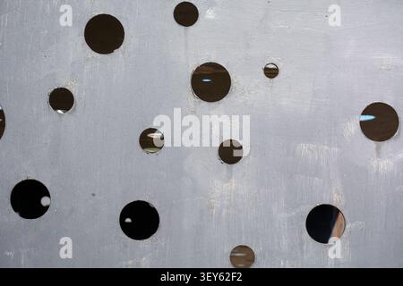 Industrial abstract background featuring a weathered metallic surface with circular cutouts, offering an edgy geometric pattern with versatile copy sp Stock Photo