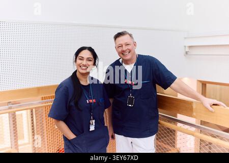 Portrait of male and female healthcare professionals posing on clinic balcony Stock Photo
