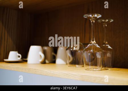 Glassware and Ceramic Cups on Wooden Kitchen Shelf Stock Photo